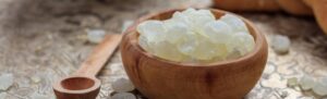 O Nas 6 Solze Chios mastike v elegantni okrogli leseni posodi, naravna alternativa žvečilnemu gumiju za podporo ustnemu zdravju in higieni.